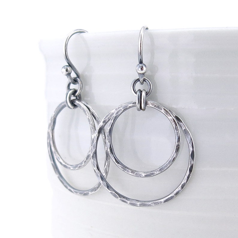 Puede incluir: Pendientes de plata martillados de doble c&iacute;rculo con acabado texturizado. Los pendientes tienen un dise&ntilde;o simple y minimalista.
