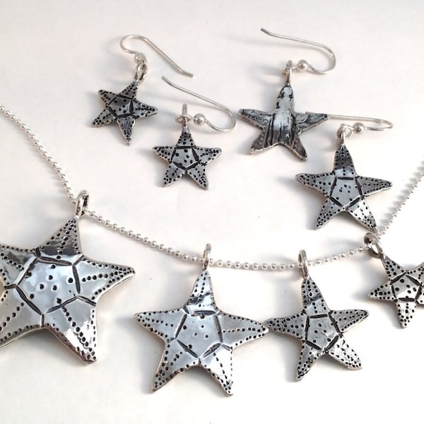 Pingente ou brincos de estrela-do-mar feitos de prata. Moedas americanas vintage: dez centavos, vinte e cinco centavos.