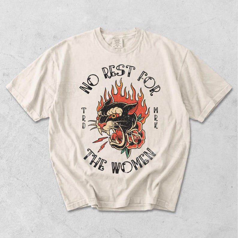 May include: Off-white t-shirt with a black panther graphic surrounded by flames and a rose, and the words "NO REST FOR THE WOMEN." The design is in a vintage tattoo style.