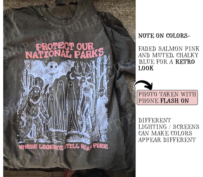 May include: A charcoal gray t-shirt featuring a graphic print in salmon pink and chalky blue. The design includes a bat, a sasquatch, ghosts, and a deer, with the text "PROTECT OUR NATIONAL PARKS" and "WHERE LEGENDS STILL ROAM FREE".
