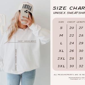 May include: White unisex sweatshirt with a size chart. The chart shows chest measurements from 20 to 30 inches and lengths from 27 to 32 inches. The measurements may have a tolerance of +/- 1 inch.
