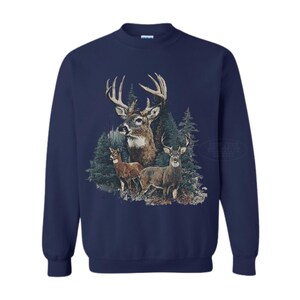 Puede incluir: Sudadera azul marino con un gr&aacute;fico detallado de ciervos en un entorno forestal. El dise&ntilde;o incluye tres ciervos, con un gran macho prominentemente exhibido, y &aacute;rboles de hoja perenne en el fondo. La sudadera tiene mangas largas y cuello redondo.