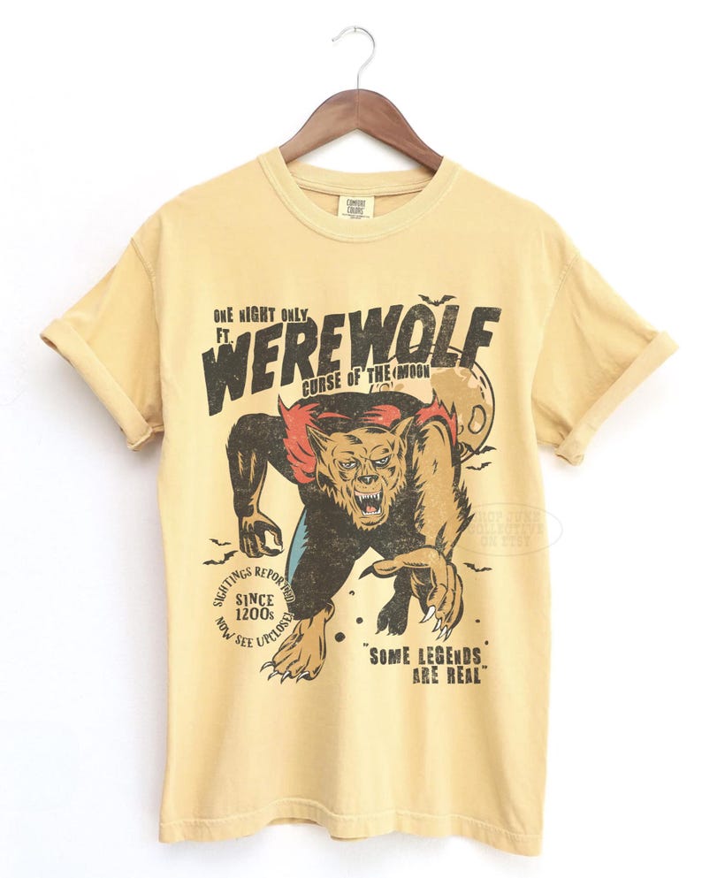 May include: A pale yellow short-sleeve t-shirt featuring a graphic of a werewolf with red accents and a full moon. The text reads: ONE NIGHT ONLY FT. WEREWOLF CURSE OF THE MOON, SIGHTINGS REPORTED SINCE 1200S NOW SEE UPCLOSE, and SOME LEGENDS ARE REAL.