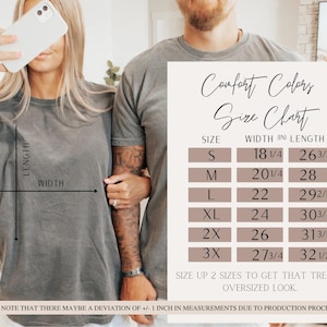 Puede incluir: Dos personas vistiendo camisetas grises Comfort Colors. La imagen incluye una tabla de tallas con medidas en pulgadas para las tallas S a 3XL. La tabla indica el ancho y el largo de las camisetas. El texto aconseja subir una talla para un look oversize.