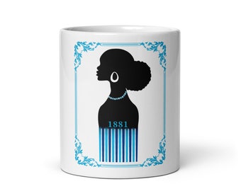 May include: White ceramic mug with a black silhouette of a woman with a blue and white striped design and the year 1881 printed on the mug.