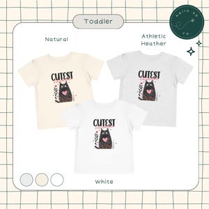 May include: Three toddler-sized t-shirts with a black cat graphic and the text "Cutest Valentine" in pink. The shirts are available in natural, athletic heather, and white.