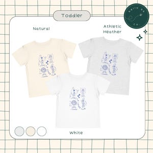 May include: Three toddler-sized t-shirts in white, natural, and athletic heather colors. Each shirt features a blue graphic of a cartoon character with the text "Pasta Lover Club".