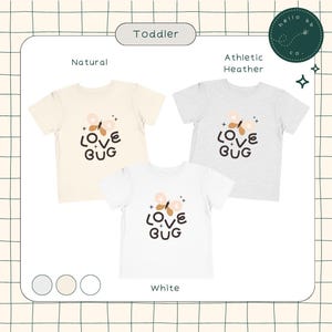 May include: Three toddler-sized t-shirts with a butterfly and the text "LOVE BUG" in brown and white. The shirts are available in natural, athletic heather, and white.