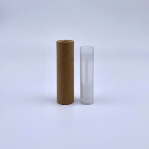 May include: A brown cardboard tube and a clear plastic tube, both cylindrical in shape. The tubes are empty and appear to be for storing lip balm or other small items.