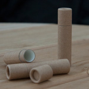 May include: Four brown cardboard tubes, one standing upright and three lying down. The tubes are made of recycled paper and are perfect for storing small items.
