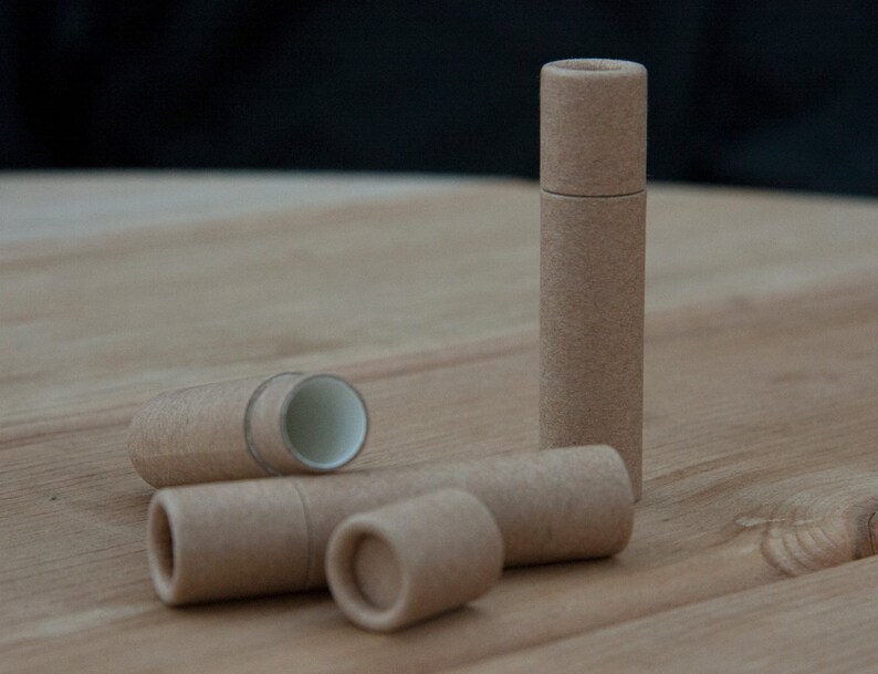 May include: Four brown cardboard tubes, one standing upright and three lying down. The tubes are made of recycled paper and are perfect for storing small items.