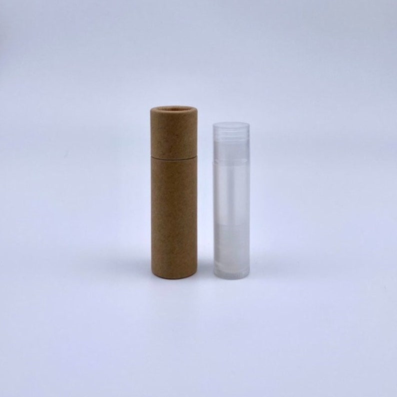 May include: A brown cardboard tube and a clear plastic tube, both cylindrical in shape. The tubes are empty and appear to be for lip balm or other similar products.