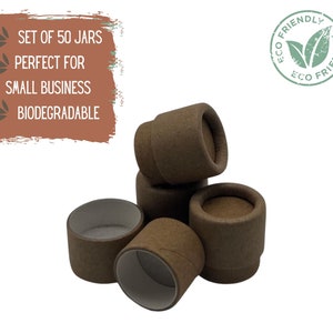 May include: Set of 50 brown cardboard jars with white interiors. The jars are stacked and arranged in a pile. The text "ECO FRIENDLY" is printed on a green leaf logo.