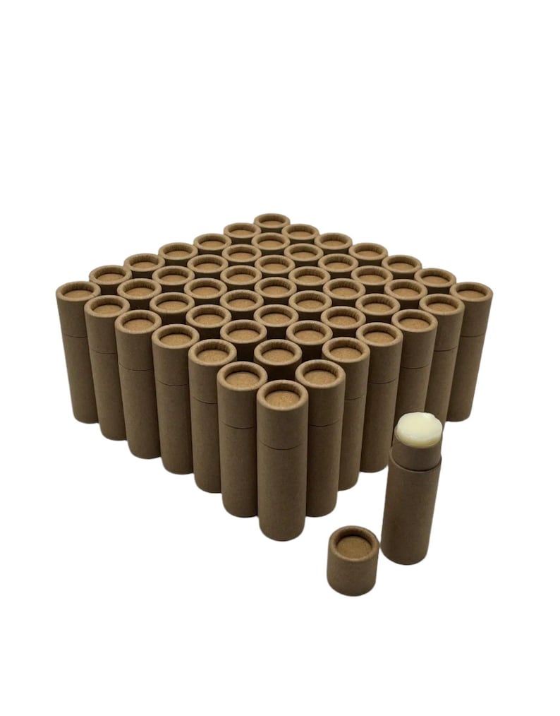 May include: A bulk pack of 50 brown cardboard tubes, perfect for packaging lip balm, salves, or other small items. The tubes are arranged in a square formation, with one tube open and showing a white balm inside.