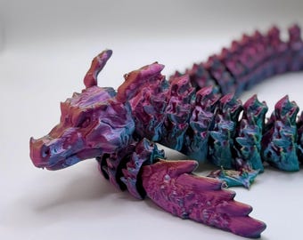 May include: A 3D printed dragon figurine with a segmented body, iridescent purple and blue paint, and a detailed head with a long snout.
