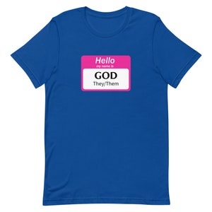 Puede incluir: Una camiseta azul real con una etiqueta de nombre rosa que dice "Hola, mi nombre es DIOS Ellos/Ellas".