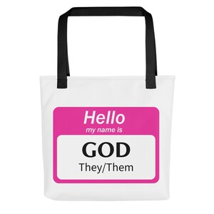 Puede incluir: Una bolsa de tela blanca con asas negras presenta una etiqueta de nombre rosa que dice "Hello my name is GOD They/Them".
