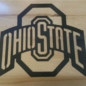 May include: Black metal Ohio State logo with a large "O" in the center and the words "Ohio State" arched around it.