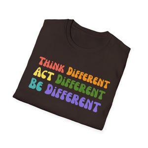 May include: A dark brown t-shirt with the words "THINK DIFFERENT, ACT DIFFERENT, BE DIFFERENT" in colorful, retro-style lettering. The text is stacked vertically, with each word in a different color.