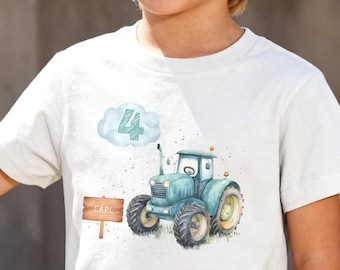 Op de afbeelding: Een wit t-shirt met korte mouwen en een aquarelillustratie van een blauwgroene tractor. Boven de tractor zweeft een lichtblauwe wolk met het cijfer 4 erin. Links van de tractor staat een bruin houten bordje met de naam CARL erop gedrukt.