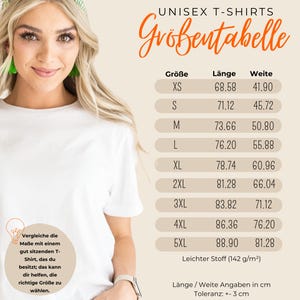 May include: Unisex t-shirt size chart in centimeters. The chart shows sizes XS through 5XL with corresponding length and width measurements. The text "Leichter Stoff (142 g/m&sup2;)" is at the bottom of the chart.