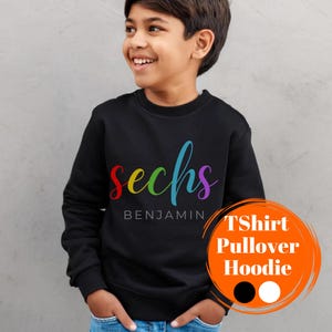 Könnte beinhalten: Schwarzer Pullover mit dem Wort "sechs" in Regenbogenfarben und dem Namen "Benjamin" darunter. Der Pullover ist als T-Shirt, Pullover oder Hoodie erhältlich.