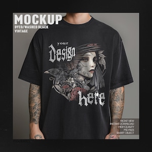 Può includere: Una maglietta nera con un aspetto vintage e lavato. La maglietta presenta un design grafico di una donna con un corvo e fiori. Il testo "Your Design Here" è stampato sulla maglietta.