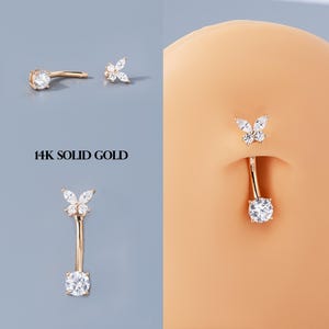 Puede incluir: Anillos para el ombligo dorados con diseños de mariposas y cristales redondos. La imagen muestra las joyas en diferentes vistas, incluyendo una barra curva y un poste recto. El texto "14K SOLID GOLD" también es visible.