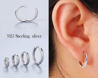 May include: A set of four silver hoop earrings. The earrings are available in three different sizes. The smallest earrings are about 1.2 cm in diameter, the medium earrings are about 2.5 cm in diameter, and the largest earrings are about 3.8 cm in diameter. The earrings are made of 925 sterling silver.