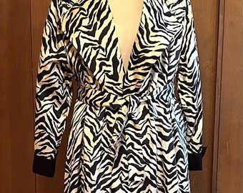 May include: A black and white zebra print satin trench coat with a black satin collar and a tie belt.