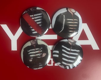 May include: Four round buttons with images of a person in a black military-style jacket with white stripes and accents. One button has a red sash. The buttons are on a red background with white text.