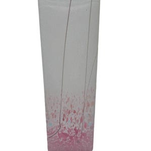 May include: A tall, rectangular glass vase with a speckled pink and white design at the base. The vase has a light grey background with thin, curved lines. The pink design transitions into the clear glass.