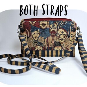 May include: A rectangular crossbody bag with a zipper closure and two straps. The bag features a print of vintage clown faces in various colors. The straps are black and tan striped. The text "BOTH STRAPS" is above the bag.