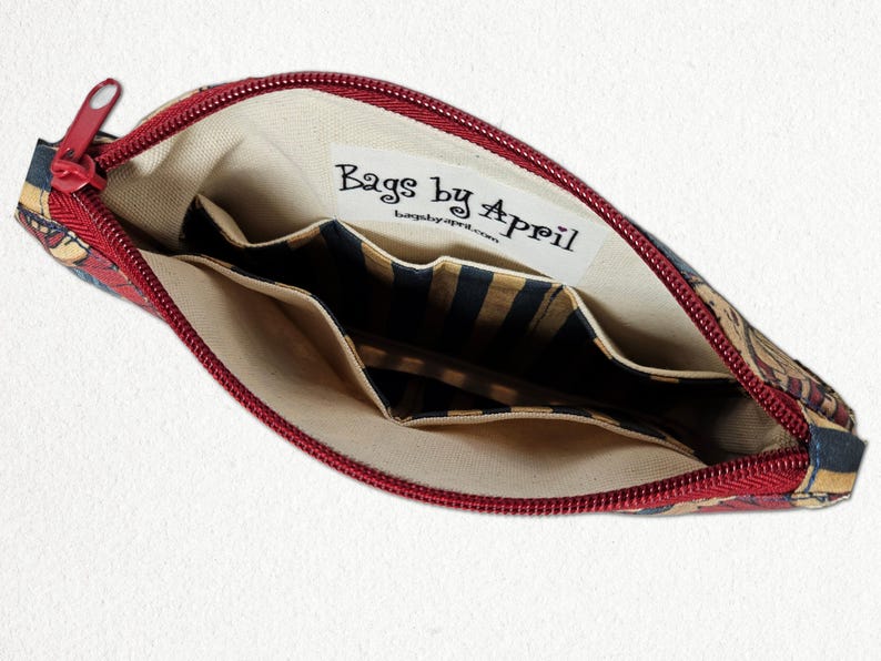 May include: Open red zippered pouch with a floral pattern. The interior features multiple pockets and a label that reads "Bags by April". The lining is beige, and the pockets have a striped design.