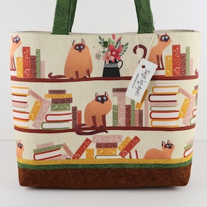 Bolso de mano con forma de gatito siamés en estanterías