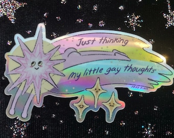 May include: A holographic sticker with a pink star with a smiling face and a rainbow shooting star with the text "Just thinking my little gay thoughts" and the artist's name "Jess Fink".