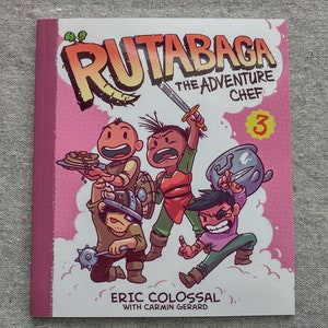 Puede incluir: Una portada de cómic rosa y blanca con el título "Rutabaga: The Adventure Chef #3". La portada presenta cuatro personajes de dibujos animados, incluyendo un chef con un cuchillo y una olla, un personaje que sostiene un plato de panqueques y un personaje que sostiene una espada. El libro es de Eric Colossal con Carmin Gerard.