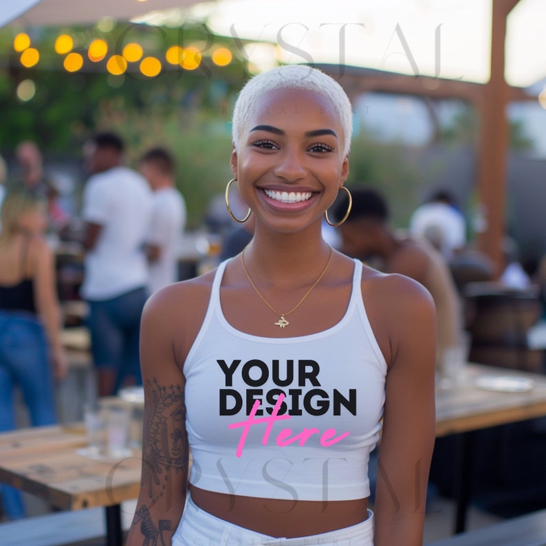 Peut inclure: Une femme portant un d&eacute;bardeur blanc avec le texte "YOUR DESIGN Here" imprim&eacute; sur le devant. Elle sourit et regarde la cam&eacute;ra.
