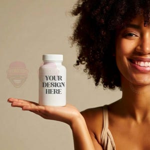 May include: A white supplement bottle with a white cap is held in a person's hand. The bottle has the text "YOUR DESIGN HERE" printed on it in a gray font. The background is a solid beige color.