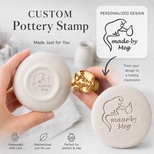 May include: A custom brass pottery stamp featuring a cat design with the text "made by Meg". The stamp is shown creating an impression on a round piece of light-colored clay. The image includes text labels "CUSTOM Pottery Stamp" and "PERSONALIZED DESIGN".