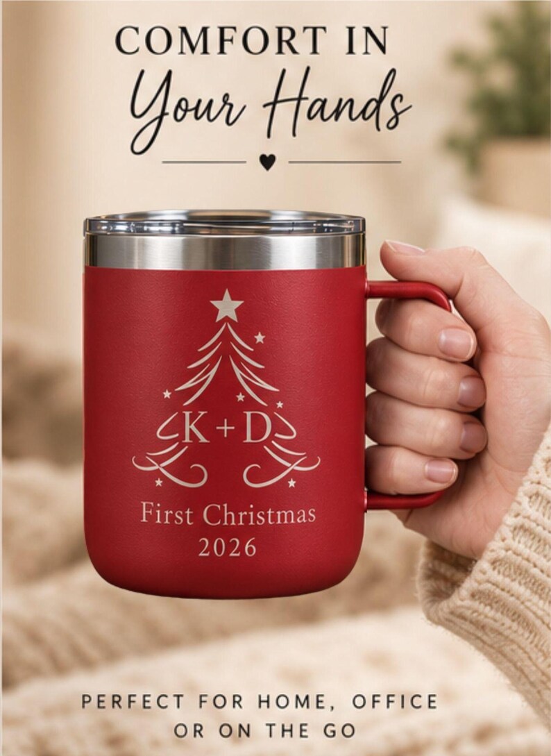 May include: A red insulated mug with a silver rim and handle, featuring a white engraved Christmas tree graphic with the text K + D, First Christmas 2026. The image includes the text Comfort in Your Hands and Perfect for Home, Office or on the Go.