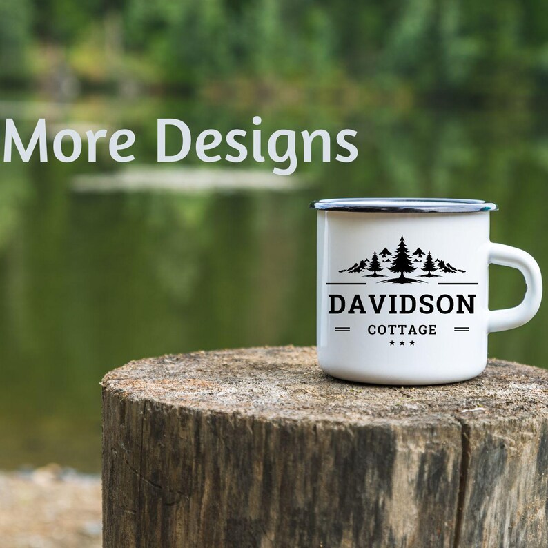 Op de afbeelding: Witte emaille campingmok met een zwarte rand en handvat. De mok heeft een zwarte afbeelding van dennenbomen en de tekst "DAVIDSON COTTAGE" in een schreefletter. De mok staat op een houten stronk.