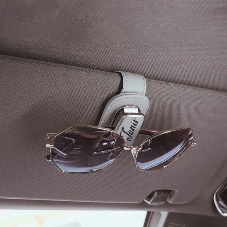Close-up of custom engraved glasses case clipped to car visor, functional and stylish accessory for daily use.