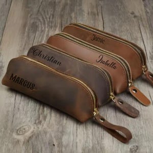 Elegant brown leather pencil case with a zipper, perfect for storing pens and brushes.