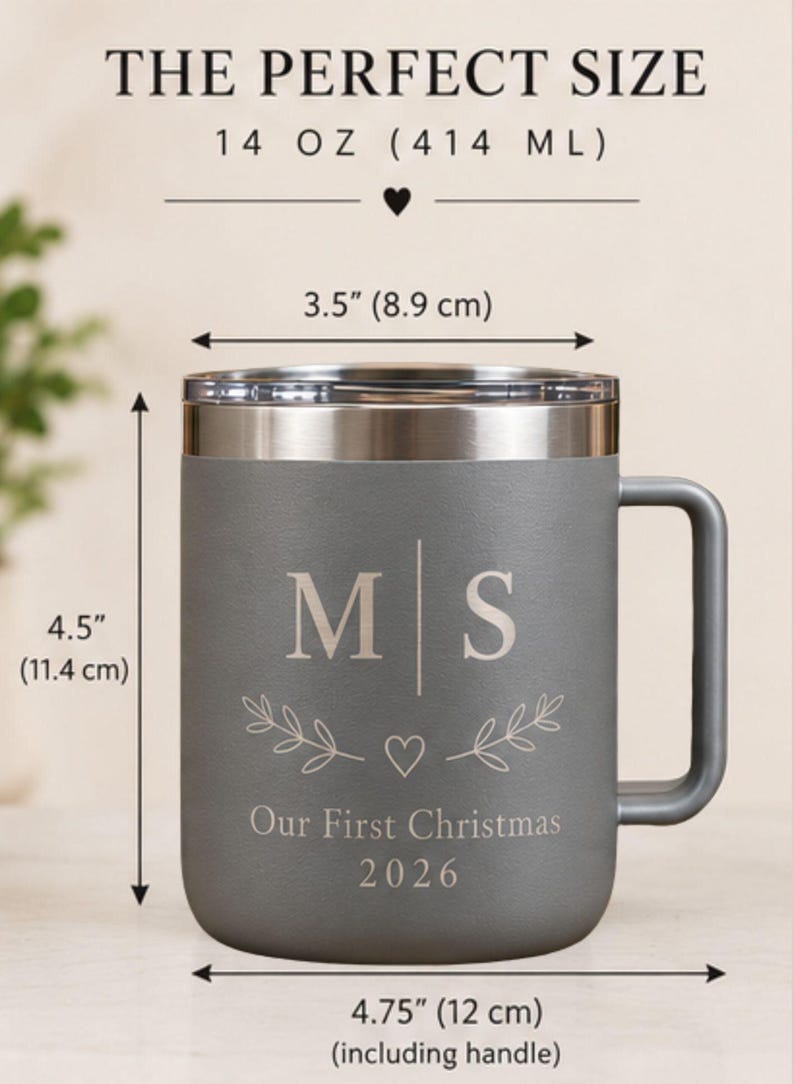 May include: A gray stainless steel mug with a handle and lid, featuring the text THE PERFECT SIZE, 14 OZ (414 ML), M | S, a heart, leaf sprigs, Our First Christmas, and 2026. Dimensions are 3.5 inches wide, 4.5 inches high, and 4.75 inches wide total.
