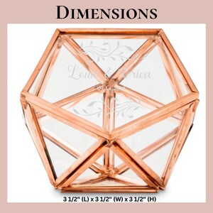 K&ouml;nnte beinhalten: Ein geometrisches Glasterrarium mit einem kupferfarbenen Metallrahmen. Die Glasscheiben sind mit floralen Verzierungen und dem Text "Louie & Erica 09.14.2024" graviert. Der Beh&auml;lter misst 8,89 cm in der L&auml;nge, 8,89 cm in der Breite und 8,89 cm in der H&ouml;he.