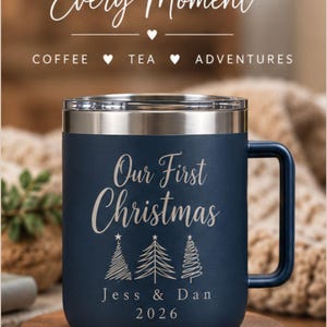 May include: A dark blue insulated mug with a silver rim and handle, featuring the text "MADE FOR Every Moment COFFEE &hearts; TEA &hearts; ADVENTURES" and "Our First Christmas" above three line-art Christmas trees, "Jess & Dan", and "2026".