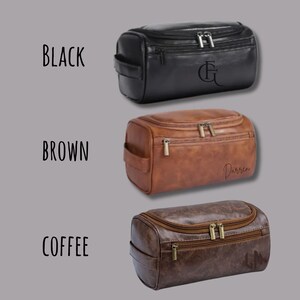 May include: Three leather wash bags in black, brown, and coffee shades. Each bag features a zipped top and a side handle. The black bag has initials, the brown bag has a name, and the coffee bag has a design.