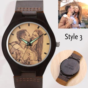Pode incluir: Um rel&oacute;gio de pulso de madeira marrom com uma pulseira de couro. O mostrador do rel&oacute;gio tem um fundo marrom claro com uma imagem gravada em preto e branco de um casal. A parte de tr&aacute;s do rel&oacute;gio tem o texto "I love you every second" gravado.