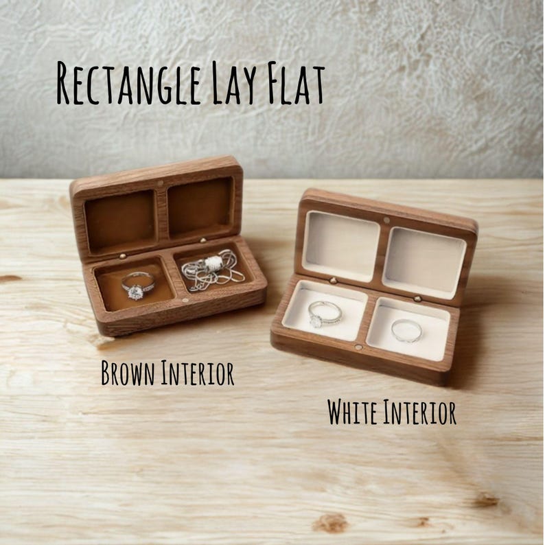 May include: Two wooden rectangle lay flat ring boxes, one with a brown interior and the other with a white interior. The brown interior box contains a ring and a necklace. The white interior box contains two rings. Text on the image reads "Rectangle Lay Flat", "Brown Interior", and "White Interior".